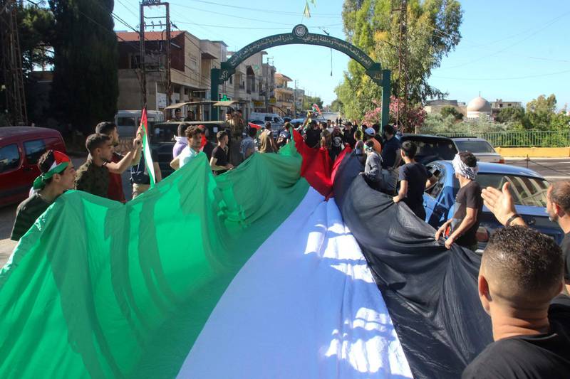 Pro-Palestinian protesters march with a large flag during a rally in the southern Lebanese village of Adaisseh, marking the Nakba and denouncing Israeli violence in Gaza and Jerusalem. AFP