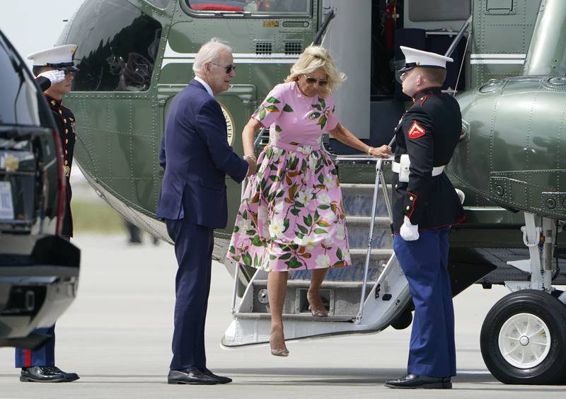 Mr Biden helps his wife exit Marine One. AP