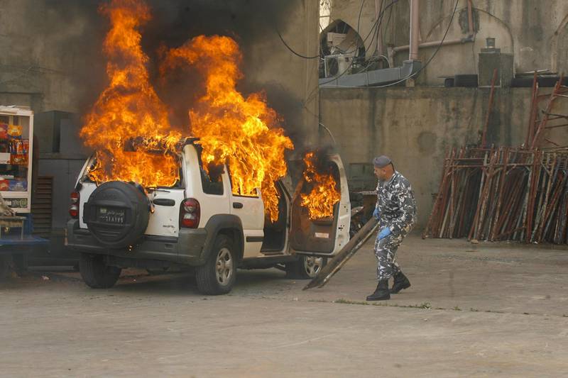 A Lebanese policeman reacts as his jeep is engulfed in flames during clashes between protesters and Lebanese soldiers in the northern port city of Tripoli.   AFP