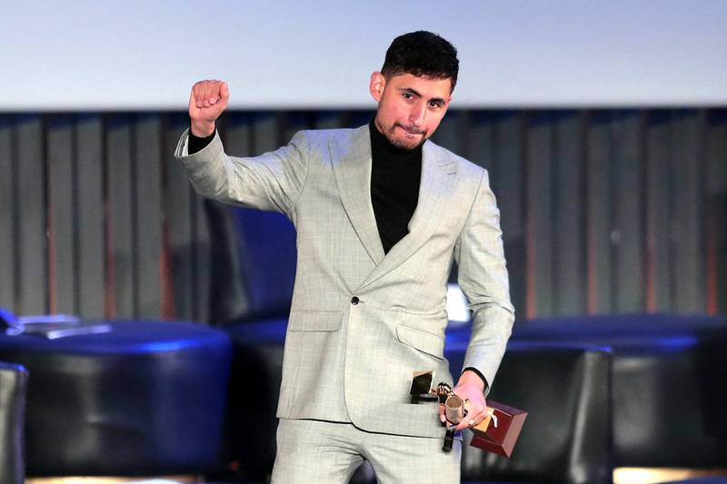 Egyptian actor Amir El-Masry receives the Golden Pyramid Award for Best Film (Limbo) at the closing ceremony of the 42nd Cairo International Film Festival (CIFF) in Cairo on December 11, 2020. (Photo by Mahmoud KHALED / AFP)