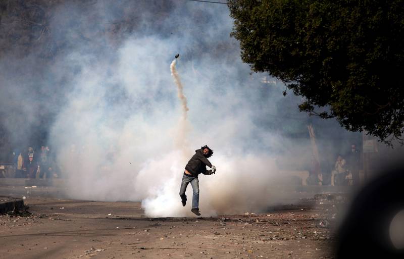 A protester throws a tear gas canister back at riot police during clashes near Tahrir Square, in Cairo, Sunday, Jan. 27, 2013. Clashes continued for the fourth successive day between protesters and police near Tahrir square, birthplace of the 2011 uprising. Police used tear gas, while the protesters pelted them with rocks. (AP Photo/Khalil Hamra) *** Local Caption ***  Mideast Egypt.JPEG-0eba1.jpg