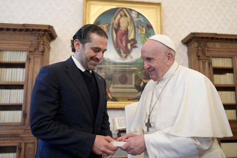 This photo taken and handout on April 22, 2021 by The Vatican Media shows Pope Francis and Lebanon's prime minister-designate Saad Hariri exchanging gifts during a private audience in The Vatican. RESTRICTED TO EDITORIAL USE - MANDATORY CREDIT "AFP PHOTO /VATICAN MEDIA / HANDOUT " - NO MARKETING - NO ADVERTISING CAMPAIGNS - DISTRIBUTED AS A SERVICE TO CLIENTS
 / AFP / VATICAN MEDIA / Handout / RESTRICTED TO EDITORIAL USE - MANDATORY CREDIT "AFP PHOTO /VATICAN MEDIA / HANDOUT " - NO MARKETING - NO ADVERTISING CAMPAIGNS - DISTRIBUTED AS A SERVICE TO CLIENTS
