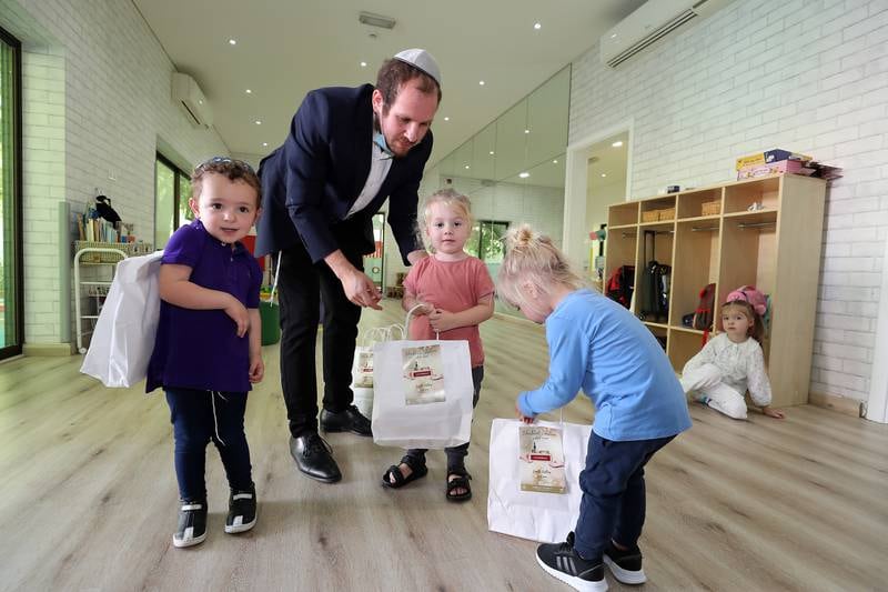 Rabbi Mendel Duchman hands out Shabbat packages to the children at Mini Miracles nursery in Dubai. Photos by Pawan Singh / The National 