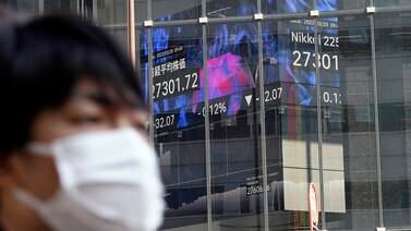 An electronic board shows share movements on Japan's Nikkei 225 index. Asian stock markets fell on Monday after Switzerland arranged the takeover of Credit Suisse. AP