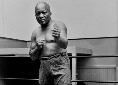 FILE - In this 1932 file photo, boxer Jack Johnson, the first black world heavyweight champion, poses in New York City. President Donald Trump on Thursday, May 24, 2018, granted a rare posthumous pardon to boxing's first black heavyweight champion, clearing Jack Johnsonâ€™s name more than 100 years after a racially-charged conviction.   (AP Photo/File)