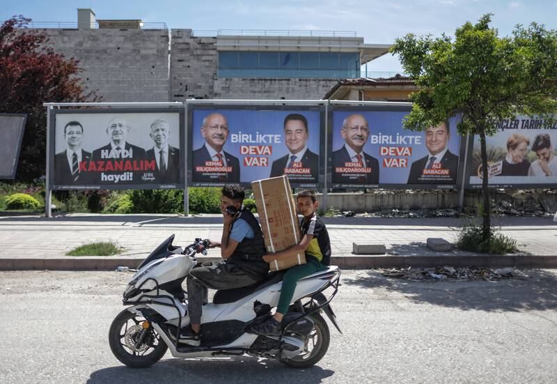People ride past pictures of the Turkish presidential candidate Kemal Kilicdaroglu, leader of the opposition Republican People's Party (CHP). EPA 