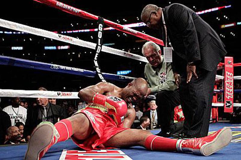 Bernard Hopkins grimaces as he clutches his left shoulder after being dumped on the canvass by his WBC light heavyweight challenger Chad Dawson. Hopkins was adjudged to lost by TKO.