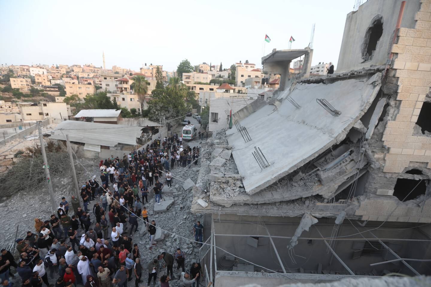 Palestinians check damage to a building after the Israeli army demolished a house in the West Bank. EPA