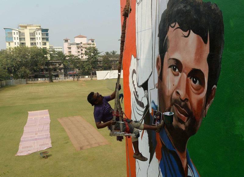 A man paints a mural of Sachin Tendulkar at a building overlooking a cricket pitch in Mumbai. Tendulkar will begin his final Test with India on Thursday. Punit Paranjpe / AFP