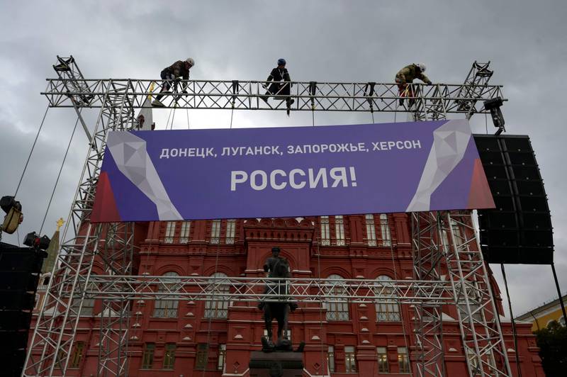 Workers fix a banner reading 'Donetsk, Luhansk, Zaporizhzhia, Kherson - Russia!' to the State Historical Museum near Red Square in Moscow. AFP
