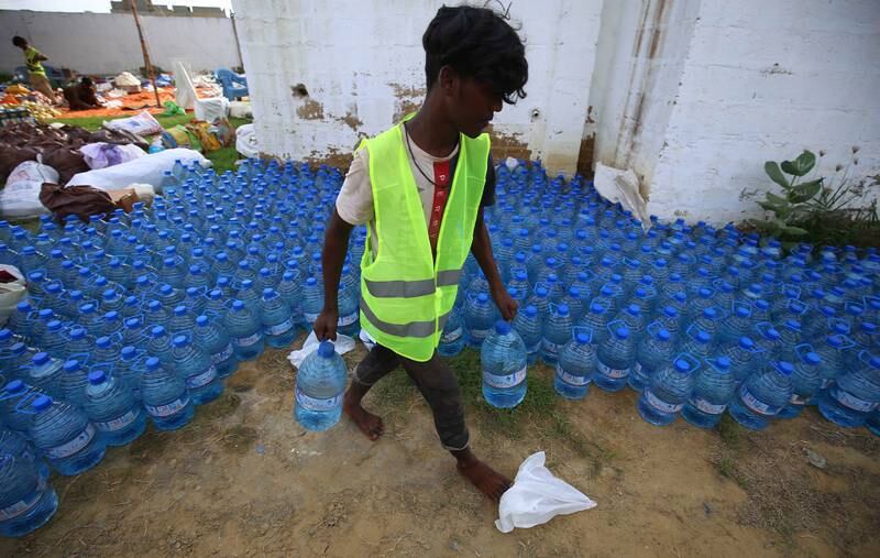 Workers from the Nikhil Foundation sort water bottles to be distributed among the people recovering from floods in Karachi, Pakistan. EPA