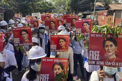 Protesters hold portraits of deposed Myanmar leader Aung San Suu Kyi in Mandalay. AP Photo