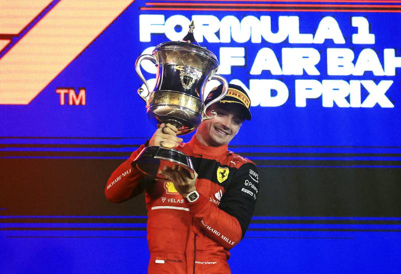 Ferrari's Charles Leclerc celebrates on the podium with the trophy. Reuters