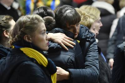 Relatives and colleagues attend a tribute ceremony and react in front of the flag-draped coffins of the 11 Ukrainians who died in a plane mistakenly shot down by Iran during a spike in tensions with Washington, which arrived in Boryapil airport, outside Kiev, on January 19, 2020. - Ukarine's President, Prime Minister and other officials attend the solemn ceremony at Kiev's Boryspil airport to see caskets with the remains of the downed plane's nine Ukrainian flight crew and two passengers being removed from the aircraft. (Photo by Sergei SUPINSKY / AFP)