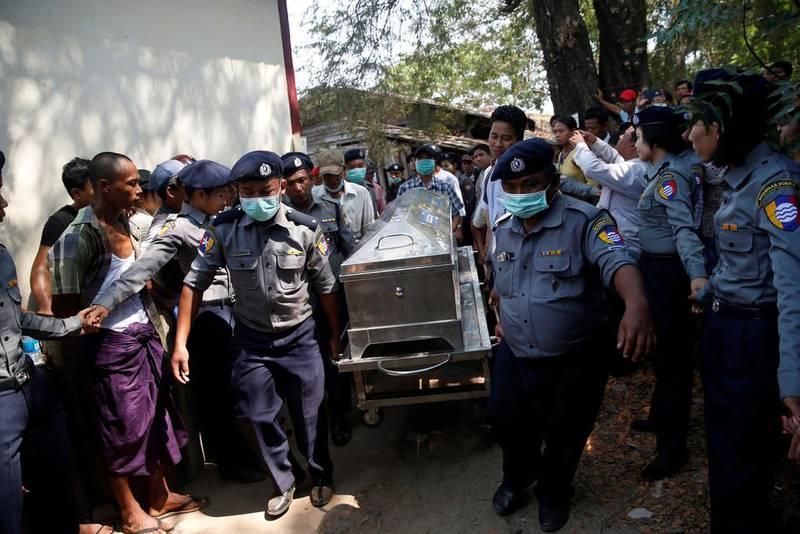 Police carry a victim’s body to Pathein General Hospital after a boat with 60 passengers returning from a wedding struck a barge and capsized in Pathein river, Myanmar, yesterday. Soe Tun / Reuters