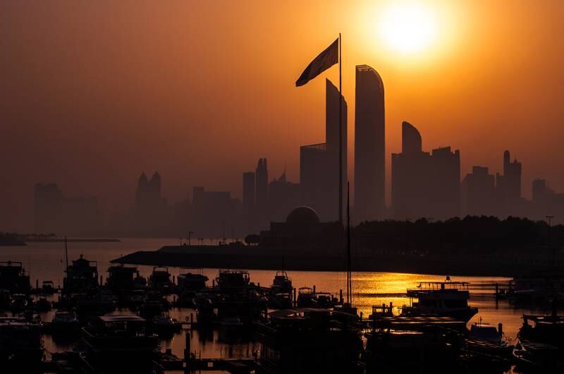 The sun rises on a hazy morning along the corniche in Abu Dhabi. Victor Besa / The National