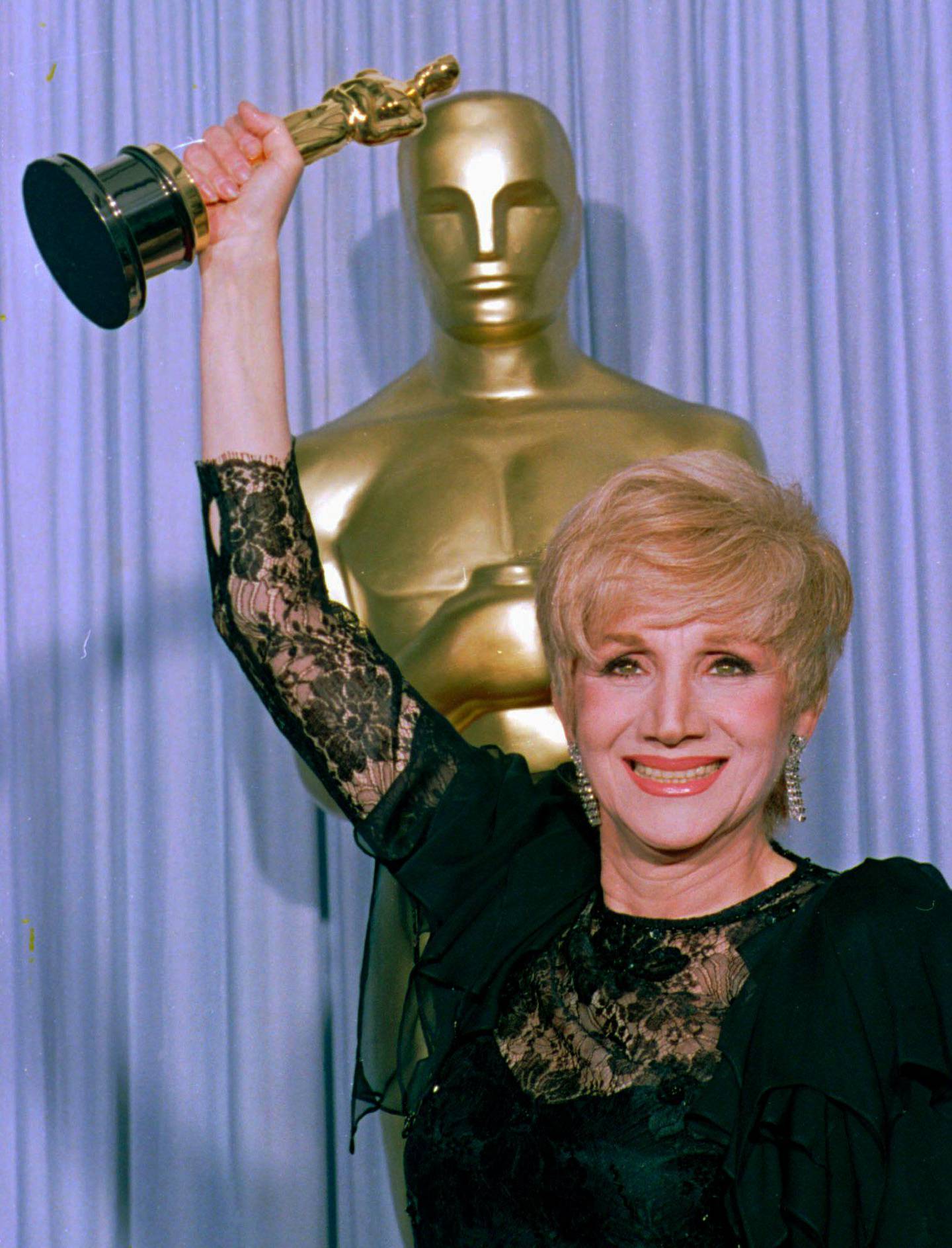 FILE - In this April 11, 1988 file photo, Olympia Dukakis holds her Oscar  at the Shrine Auditorium in Los Angles after being honored at the 60th Academy Awards as best supporting actress for her role in "Moonstrck." Olympia Dukakis, the veteran stage and screen actress whose flair for maternal roles helped her win an Oscar as Cherâ€™s mother in the romantic comedy â€œMoonstruck,â€ has died. She was 89. (AP Photo/Lennox Mcleondon, File)