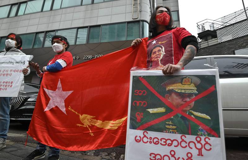 Myanmar protesters hold a flag of the National League for Democracy party during a demonstration condemning the military coup in Myanmar, near the military office of the Myanmar embassy in Seoul.  AFP