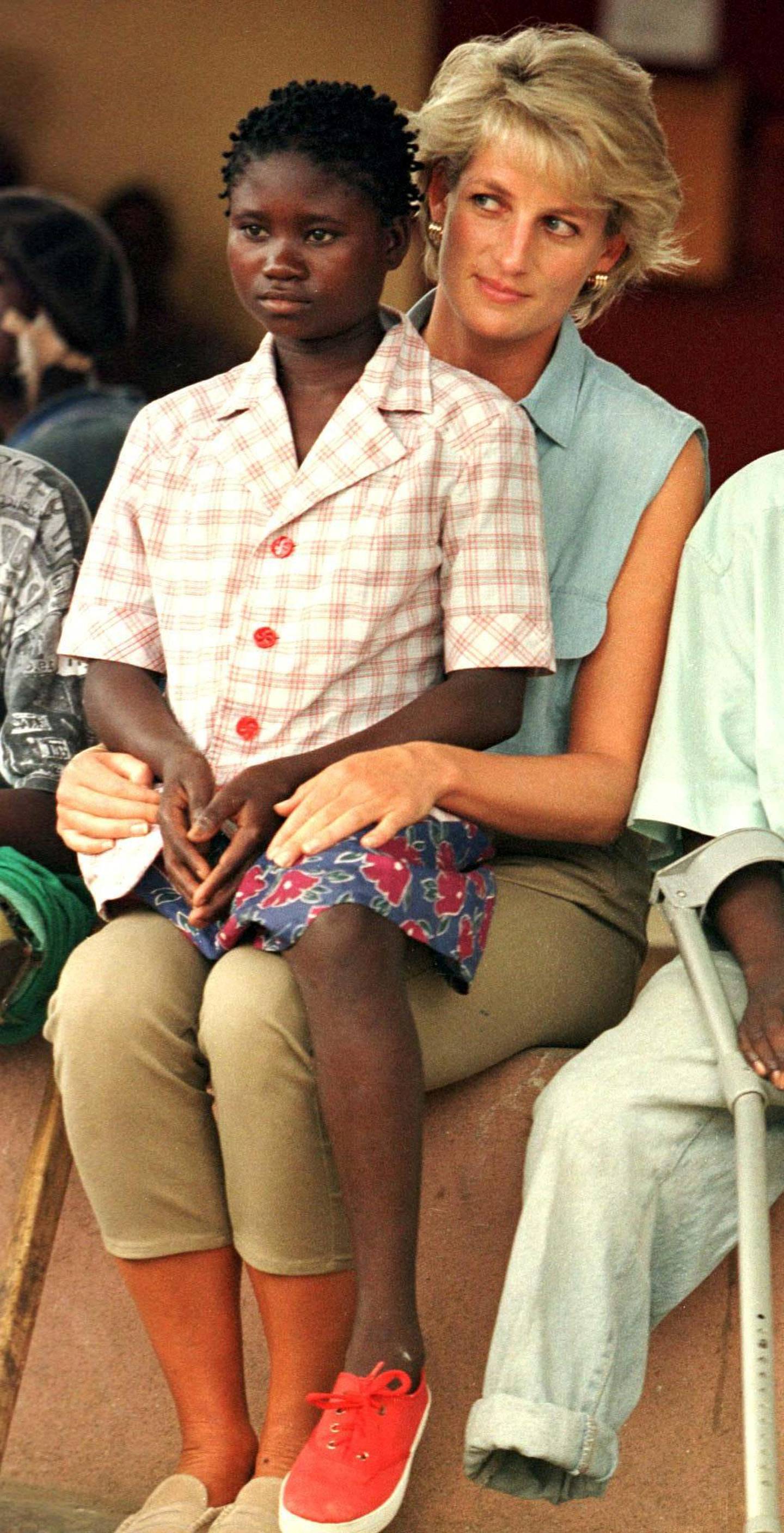 FILE PHOTO: Diana, Princess of Wales, spends time with 11-year-old Sandra Tigica, the youngest patient at the Neves Bendinha orthopaedic centre outside Luanda, Angola January 14, 1997. REUTERS/Juda Ngwenya/File Photo