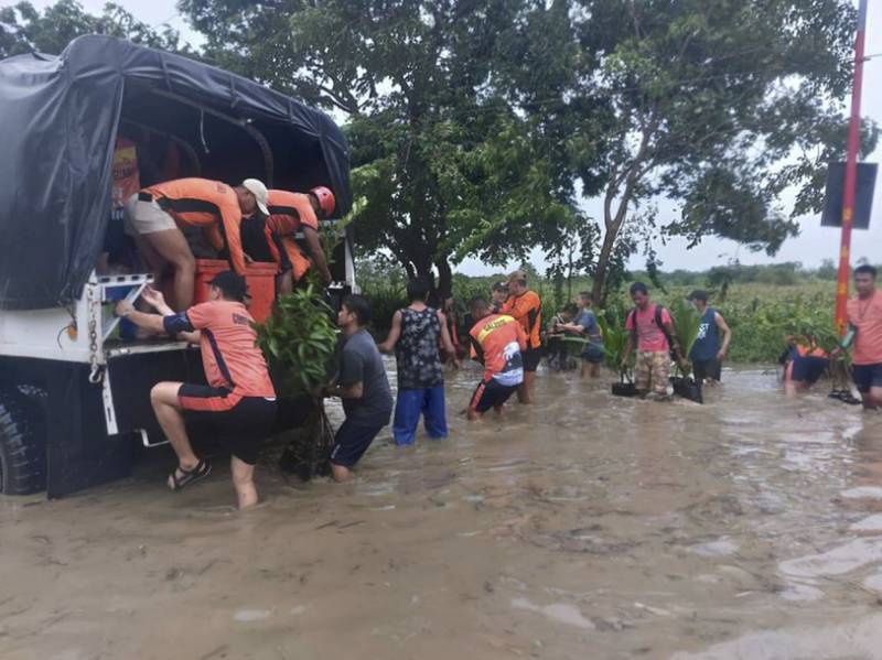 Rescuers help residents move to safer ground in Tuguegarao, the Philippines on Tuesday. AP