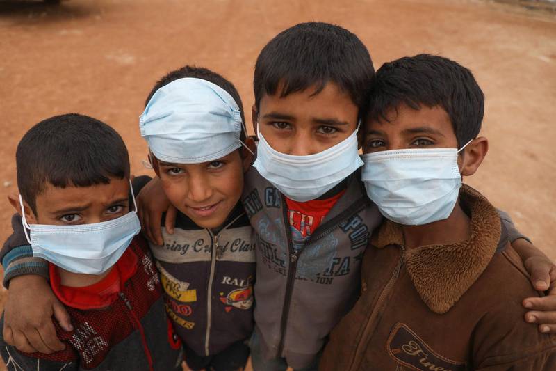 Syrian boys pose for a picture during an awareness workshop on Coronavirus held by Doctor Ali Ghazal at a camp for displaced people in Atme town in Syria's northwestern Idlib province, near the border with Turkey.  AFP