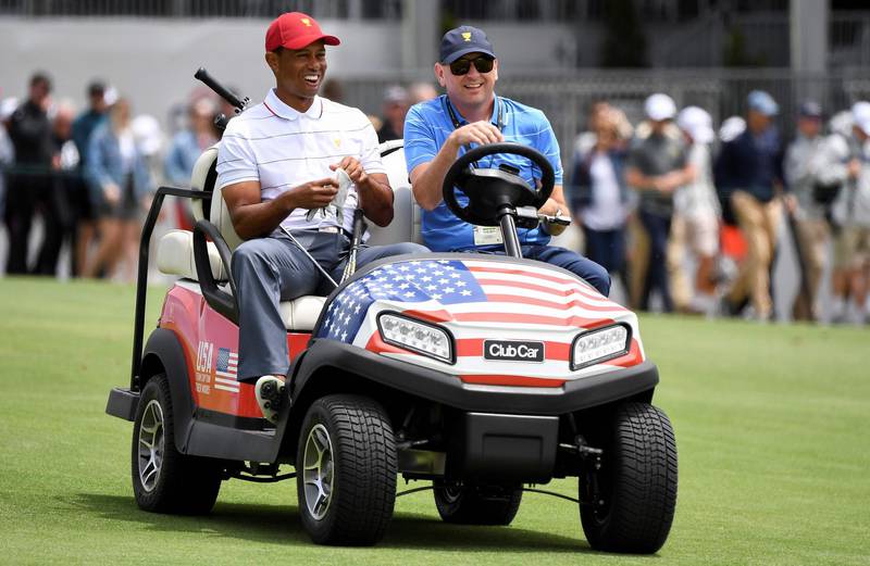 Captain of the US team Tiger Woods rides on a buggy. AFP