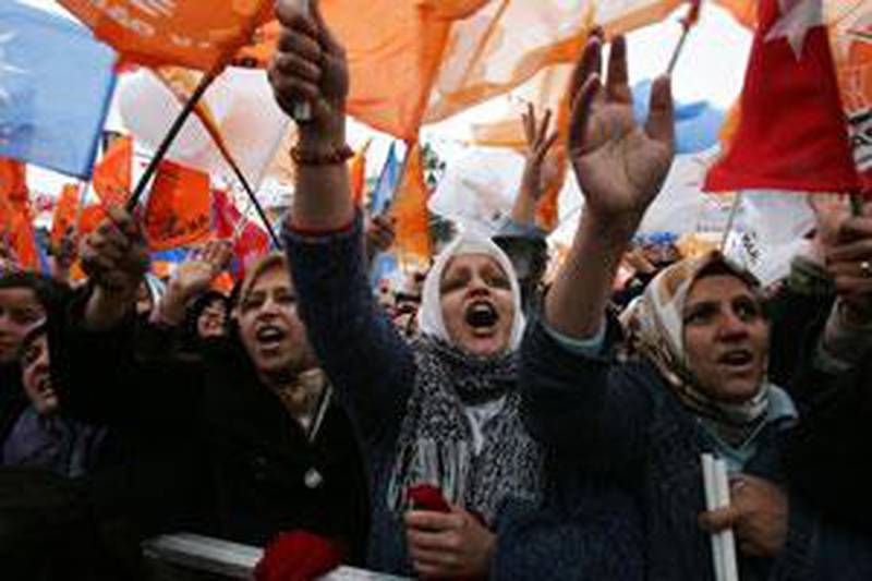 Supporters of Turkey's prime minister, Recep Tayyip Erdogan, wave flags as he delivers an election campaign speech.