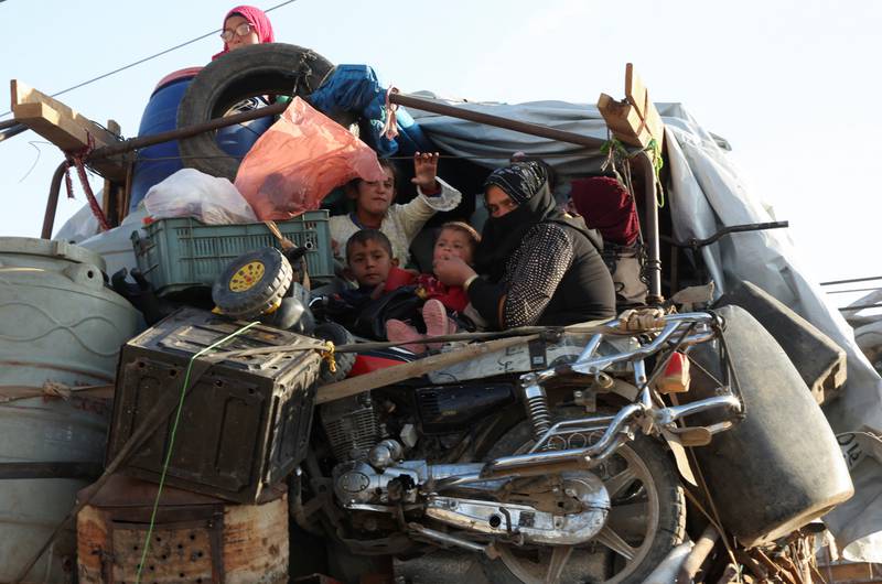 Syrian refugees sit with their belongings on a pickup truck as they prepare to return to Syria from Wadi Hmayyed, on the outskirts of the Lebanese border town of Arsal. All photos: Reuters