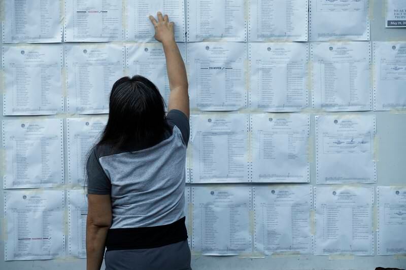 A woman looks for her name on a voters' lists posted outside a Catholic chapel in Quezon City, Metro Manila. EPA