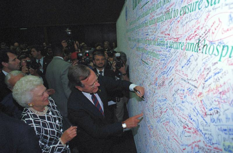 US president George W Bush and first lady Barbara Bush sign a pledge to protect the Earth in Rio de Janeiro in 1992. AP Photo