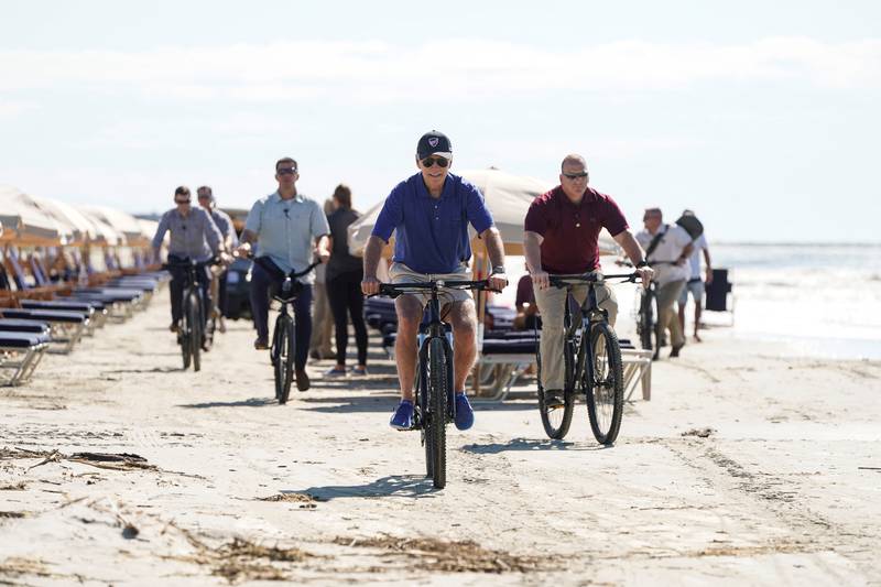 US President Joe Biden rides a bicycle on the beach on Kiawah Island. Reuters