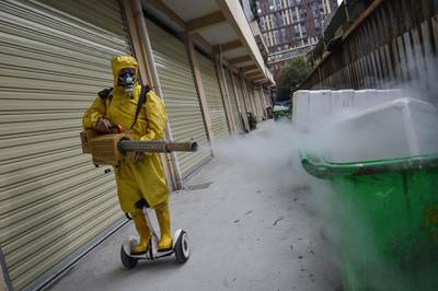 A medical staff member sprays disinfectant at a residential area in Wuhan in China's central Hubei province.  AFP