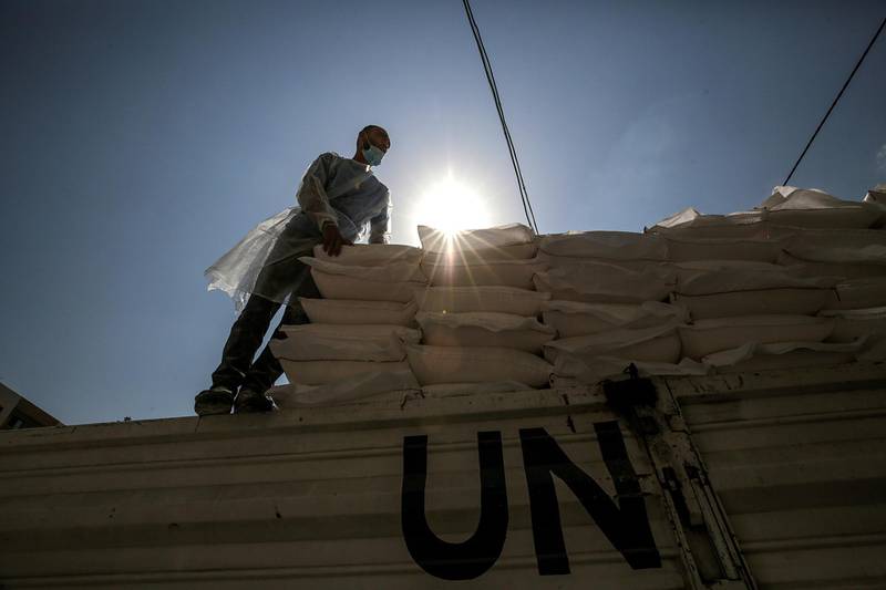 A Palestinian worker from the United Nation Relief and Works Agency (UNRWA) handles food supplies, in Gaza City. EPA