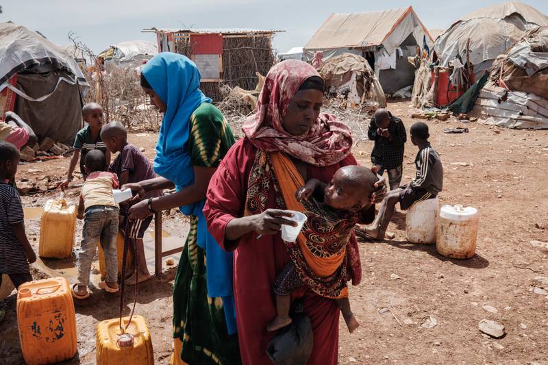Bulley Hassanow Alliyow,30, gives water to her child at Tawkal 2 Dinsoor camp for internally displaced people in Baidoa. 