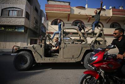 Palestinians return to Gaza City driving an Israeli Humvee that was seized after militants entered Israel. AFP