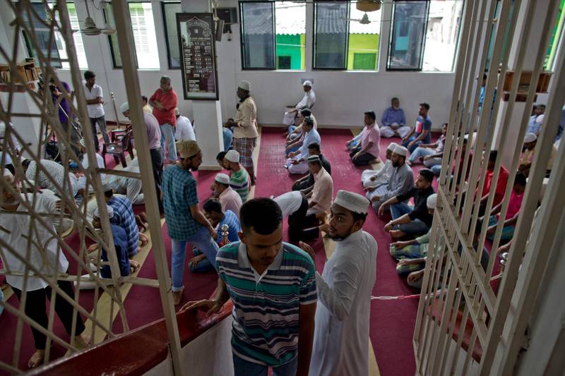 A volunteer assigned to spot unfamiliar visitors looks at a man inside a mosque in Colombo. AP Photo