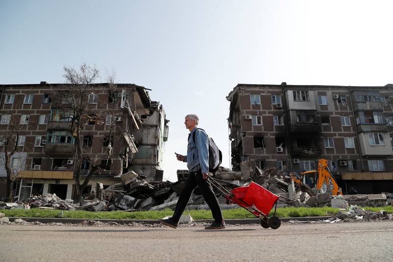 A man walks past a damaged apartment building in the southern port city of Mariupol. Reuters