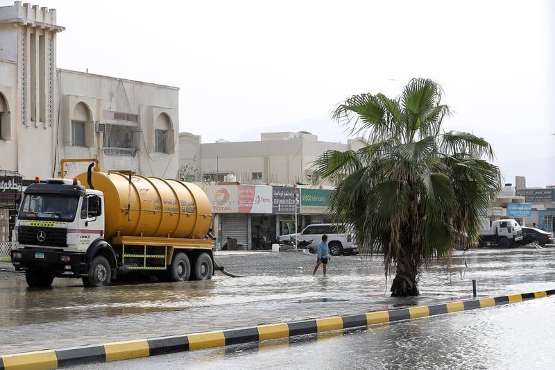 A water tank helps to clear a heavily flooded road in Kalba, Sharjah, on Monday. 

