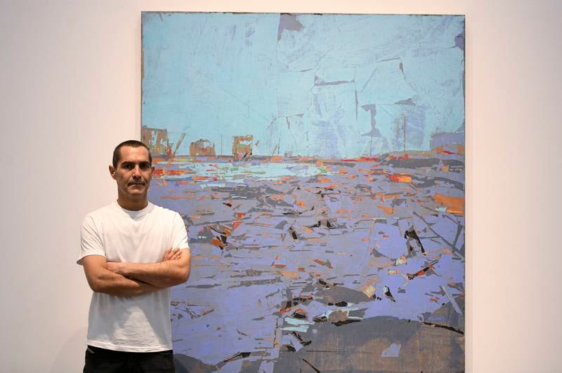 Tammam Azzam with his work Untitled at his solo exhibition Diary at Ayyam Gallery in Alserkal Avenue. Khushnum Bhandari / The National