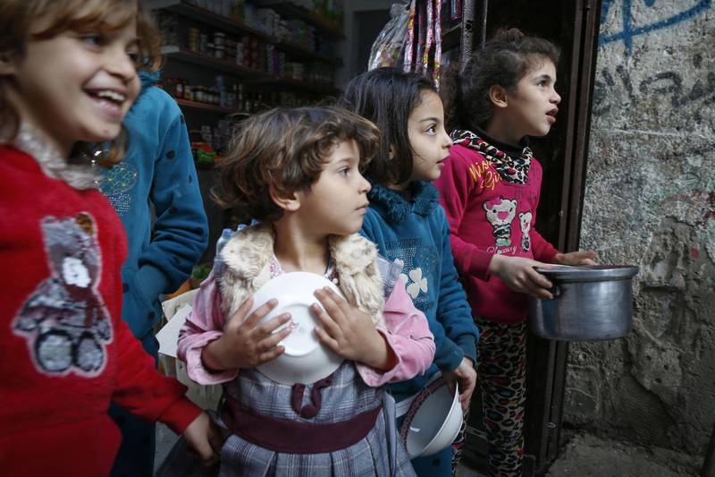 Girls in Gaza City wait to receive soup distributed by Palestinian Walid al-Hattab, out of shot, during Ramadan. AFP