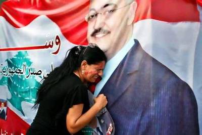 A woman mourns at a poster with an image of senior intelligence official Wissam Al Hassan during a protest against his killing, at Martyrs' square in downtown Beirut on Saturday.