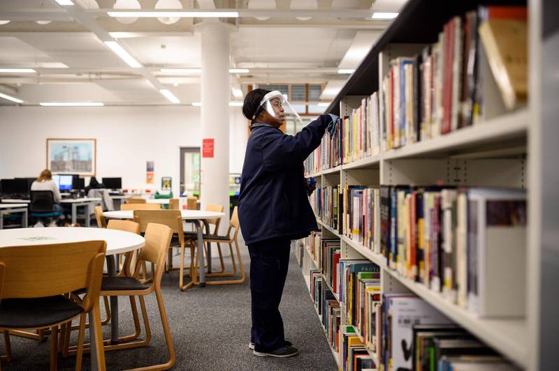 A member of staff disinfects surfaces in Coventry University Library. AFP