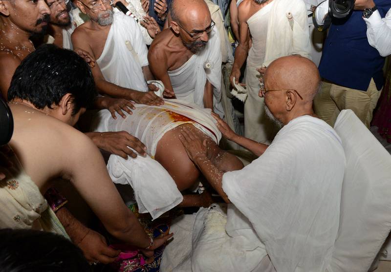 Millionaire Indian businessman Bhawarlal Doshi, centre, bends over in his new attire as he takes blessings from senior monks during a ceremony in the western city of Ahmedabad where he became a Jain monk in May 2016.