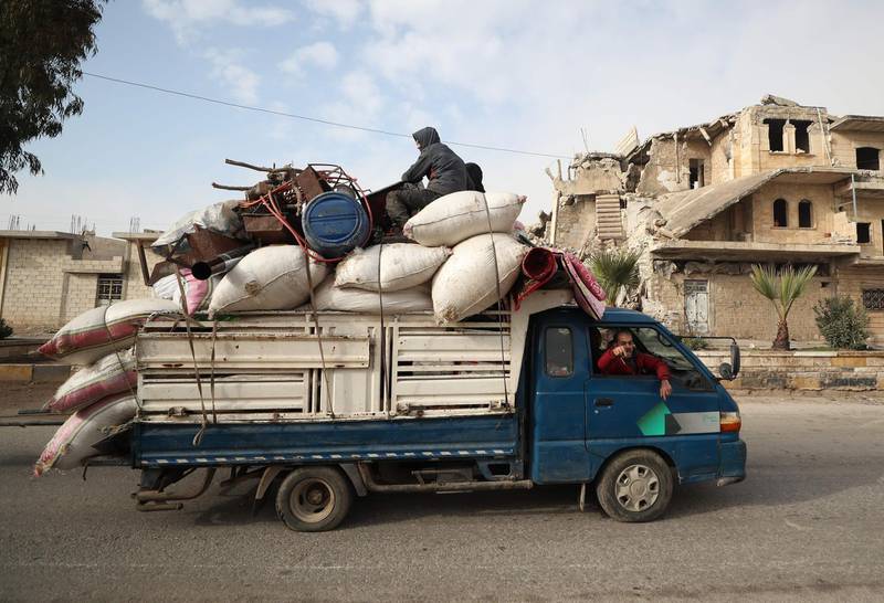 A truck loaded with furniture and other items drives carrying fleeing people away from Maaret al-Numan in Syria's northwestern Idlib province on December 24, 2019 as government forces advance. Syrian government forces on December 24 were less than four kilometres (two miles) from the strategic city of Maaret al-Numan, the head of the Britain-based monitor, Rami Abdel Rahman, told AFP. Fearing further advances, thousands of Maaret al-Numan's residents have fled.  / AFP / Omar HAJ KADOUR
