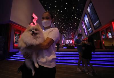 People with their pets walk arrive at the cinema on its opening day. EPA