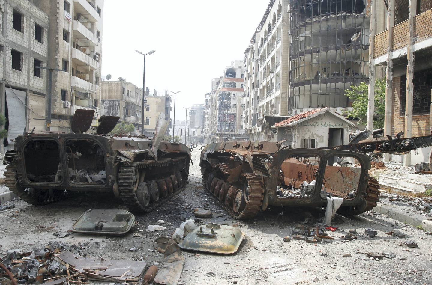 The wreckage of armoured personnel carriers belonging to the forces loyal to Syria's President Bashar al-Assad are seen at al-Hamdeya neighborhood in Homs city May 9, 2014. Around 270 Syrian rebels granted safe exit under a complex deal with President Bashar al-Assad's forces are being held in Homs by the army after insurgents elsewhere failed to uphold their side of the agreement, Syrian officials said on Friday. Following a year of siege, around 1,200 rebels and residents in the Old City of Homs left the city on buses this week in exchange for the release of dozens of captives held by rebels in the northern provinces of Aleppo and Latakia. REUTERS/Khaled al-Hariri (SYRIA - Tags: POLITICS CONFLICT CIVIL UNREST MILITARY)