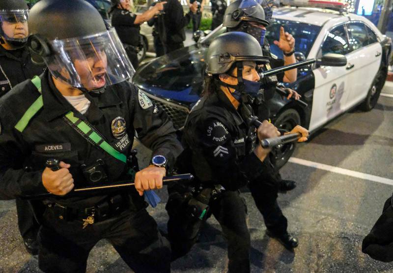 Police officers move forward to clear the street during a protest for George Floyd in downtown Los Angeles. AP Photo