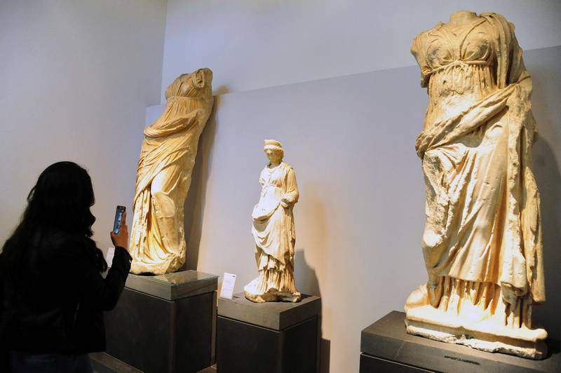In this photo released by the Syrian official news agency, SANA, a visitor takes photos during the reopening ceremony for Syria's National Museum, in Damascus, Syria, Sunday, Oct. 28, 2018. Syrian officials, foreign archeologists and restoration specialists attended the Sunday reopening ceremony in the heart of Damascus more than six years after the prominent institution was shut down and emptied as the country's civil war encroached on the capital. (SANA via AP)