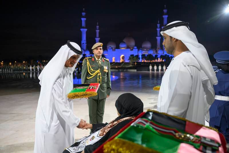 Sheikh Saud bin Saqr Al Qasimi, UAE Supreme Council Member and Ruler of Ras Al Khaimah, left, presents a medal to a family member of a martyr, during a Commemoration Day ceremony at Wahat Al Karama. All photos: UAE Presidential Court 
