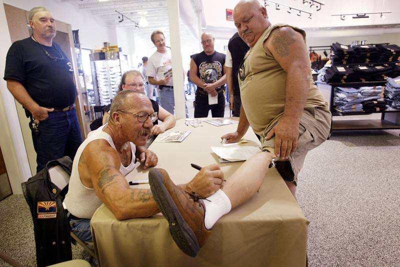 Barger autographs the artificial leg of Kenny Little at a Harley-Davidson motorcycle dealership in Quincy, Illinois. Getty / AFP